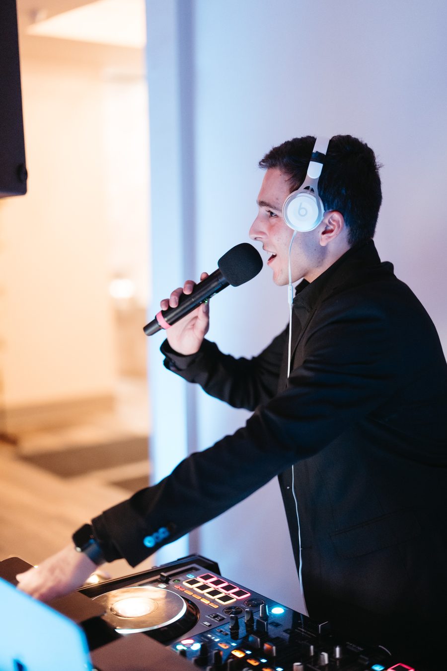Primo DJ and MC on the mic behind the decks at an event