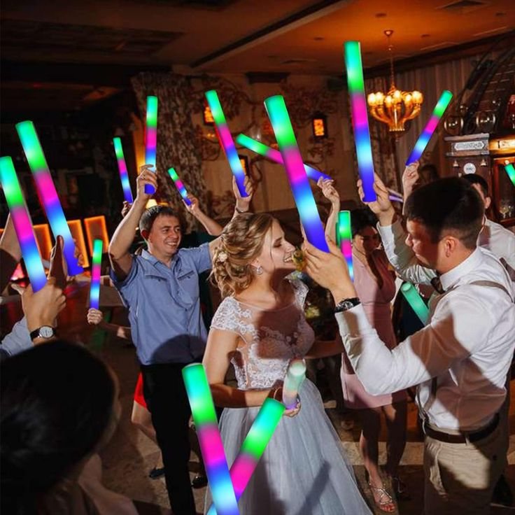 Guests waving glowing LED foam party sticks on the dance floor