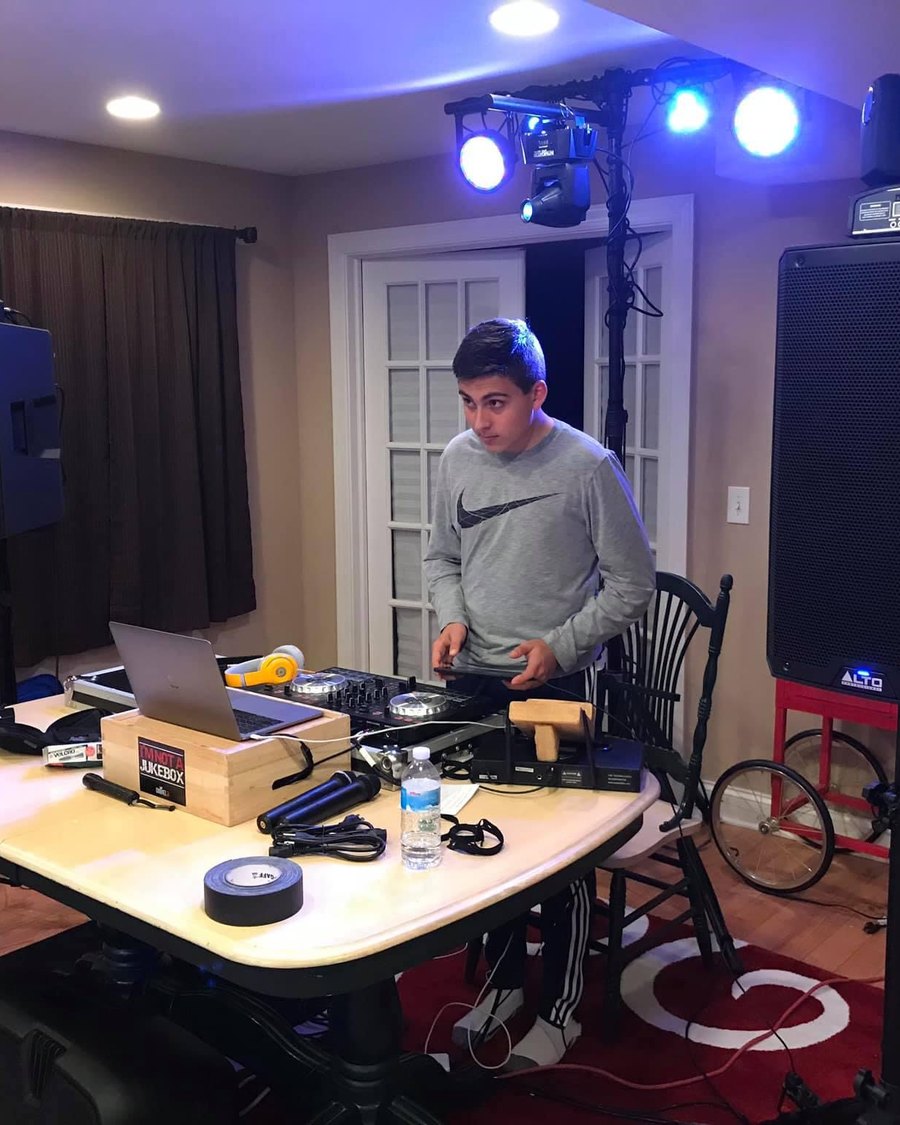 Primo at 12, DJing on a folding table in a basement with a small speaker and light