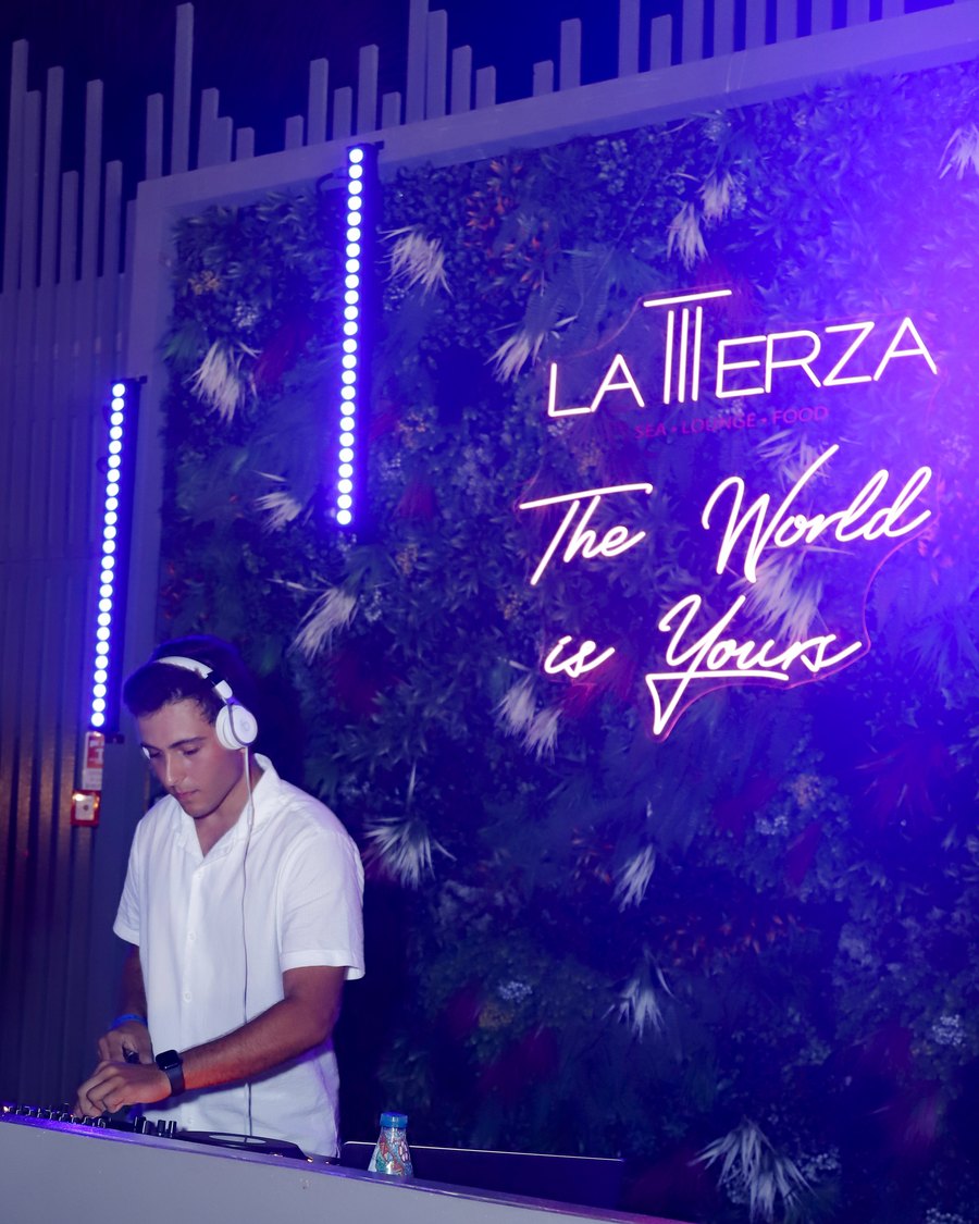 Primo DJing at La Terza in San Leone, Sicily, headphones on behind the decks