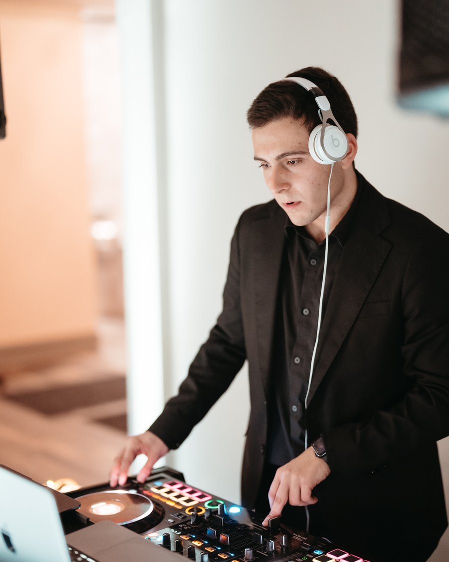 A Primo DJ in headphones working the decks at a wedding